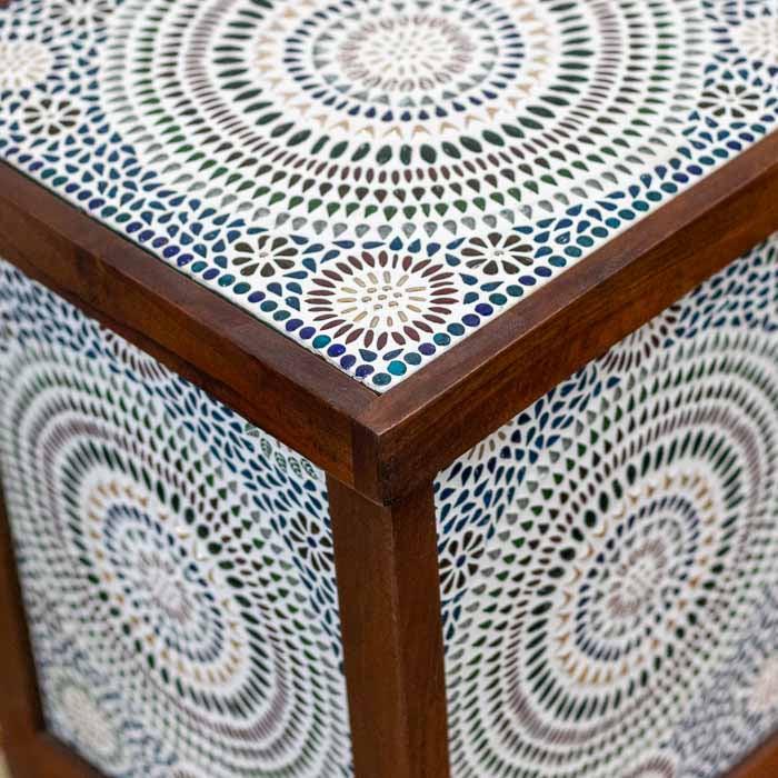 Móvel multifuncional que une mesa lateral e luminária cênica com mosaico oriental.