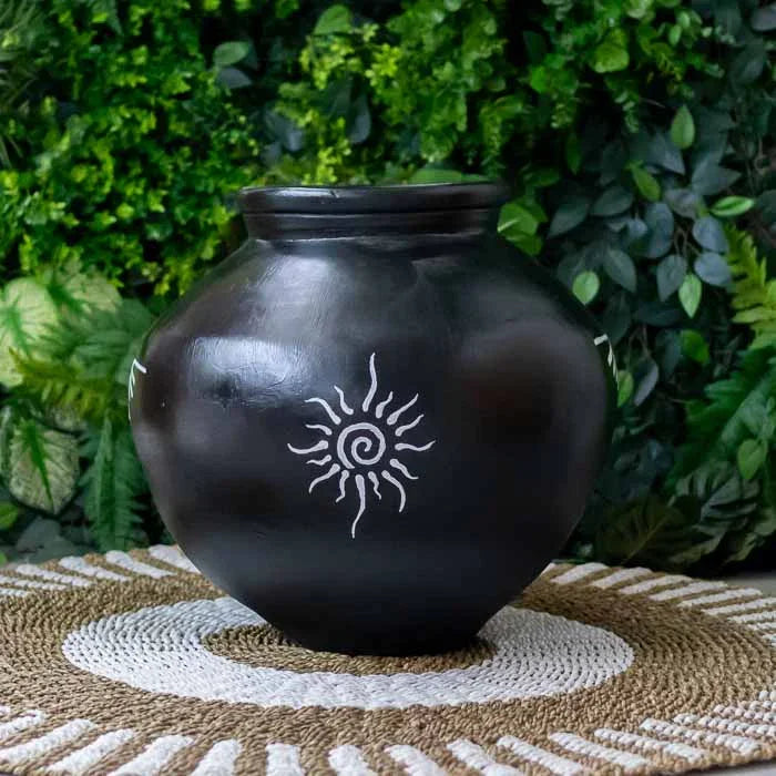 Vaso artesanal em terracota preta com símbolos de sol e lua.