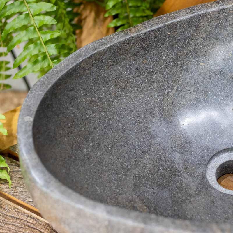 Cuba de pia artesanal esculpida em pedra natural de rio com interior polido e formato orgânico exclusivo de Bali.