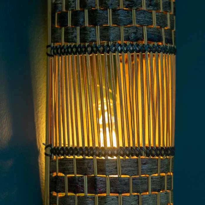 Luminária de parede com acabamento manual em casca de cipó e fibras escuras. 
