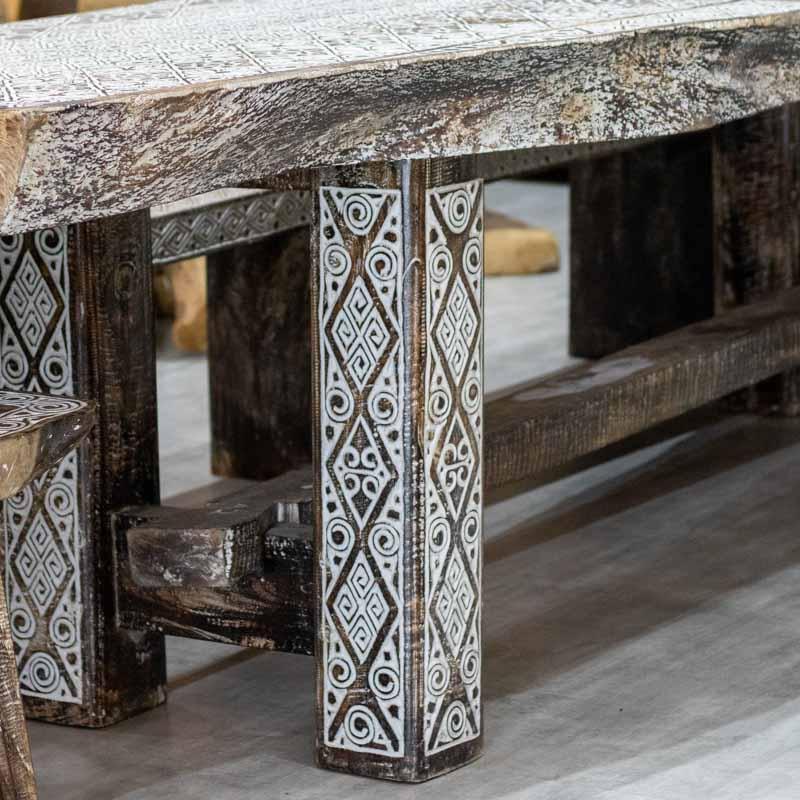 Detalhe da textura entalhada e do contraste da pátina branca em mesa de madeira rústica importada da Indonésia.