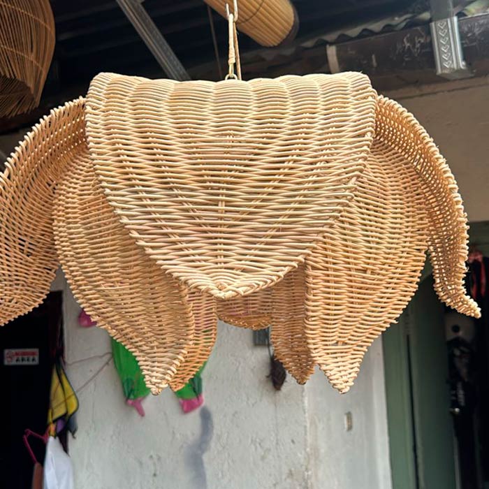 Luminária pendente de teto em rattan natural com design de pétalas sobrepostas e trançado fechado.