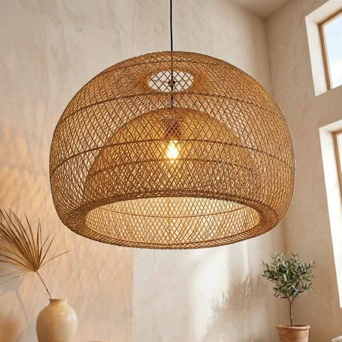 Luminária pendente de teto em formato de domo com trama geométrica vazada em rattan natural.