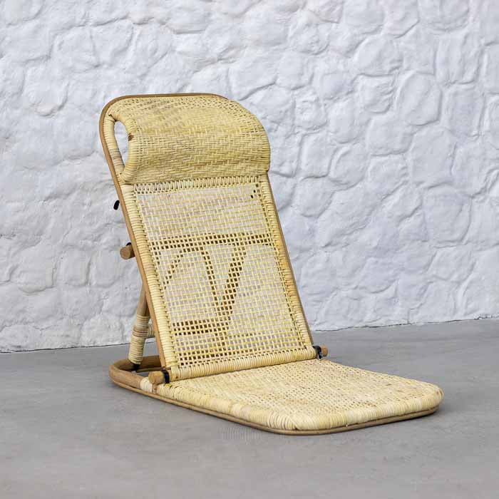 Cadeira de chão artesanal em rattan natural com encosto reclinável e assento trançado manual.