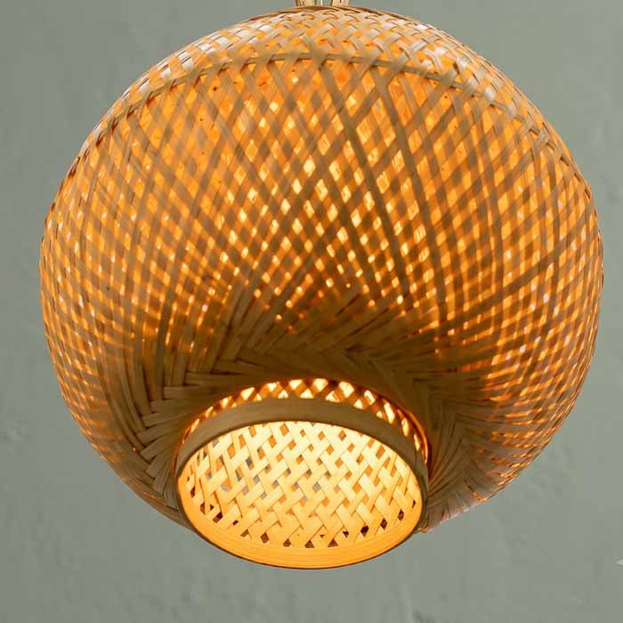 Pendente artesanal Tuhan com trama aberta projetando iluminação cênica para sala de jantar.