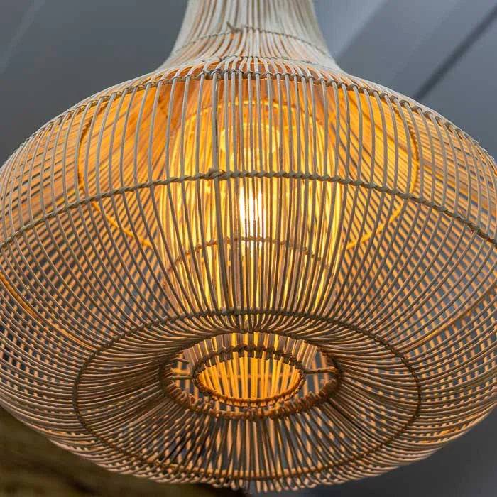 Pendente de rattan artesanal com estrutura interna metálica e luz quente ideal para espaços tropicais.