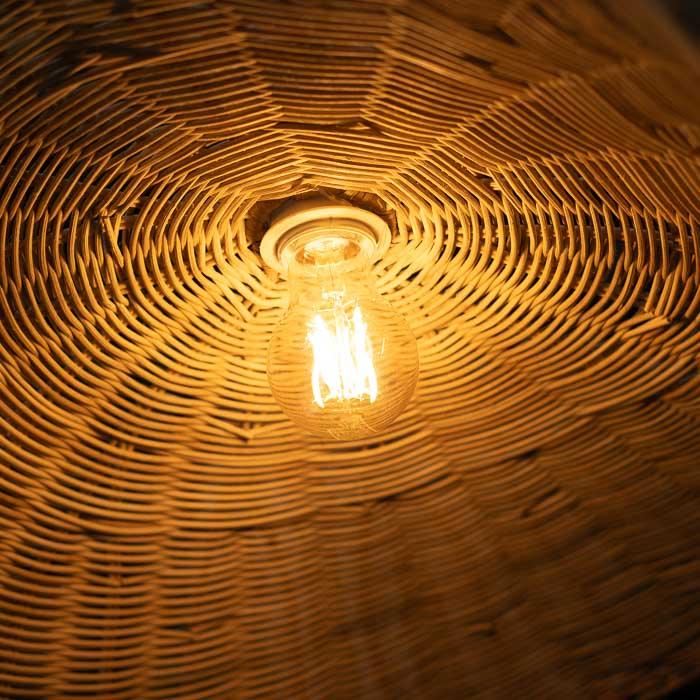Peça de rattan trançado com estrutura leve e formato boêmio. 
