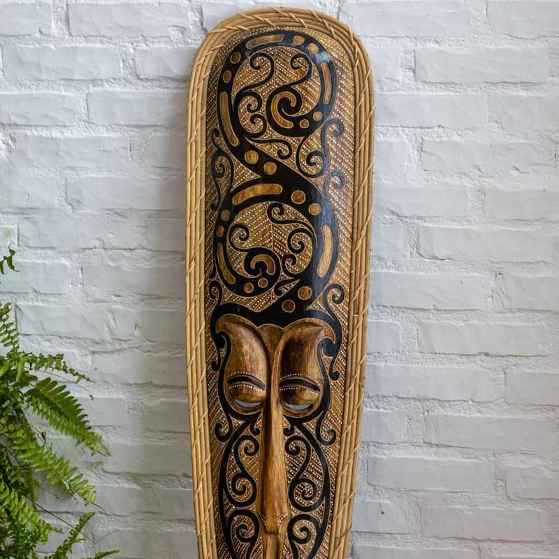 Vista frontal de máscara decorativa monumental com detalhes em rattan, ideal para projetos de interiores de luxo rústico. 