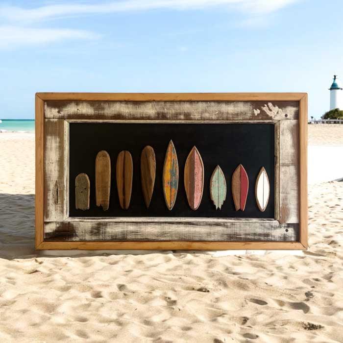 Vista frontal de quadro Surf Evolution de Criciúma/SC, evidenciando o contraste entre a madeira bruta e a arte das pranchas.