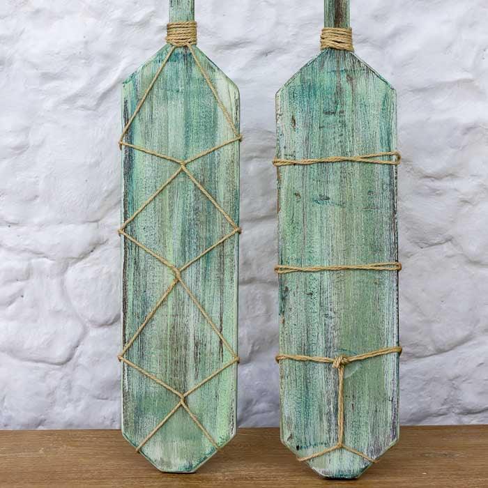 Detalhe da pátina verde/azul envelhecida, simulando o desgaste do mar.