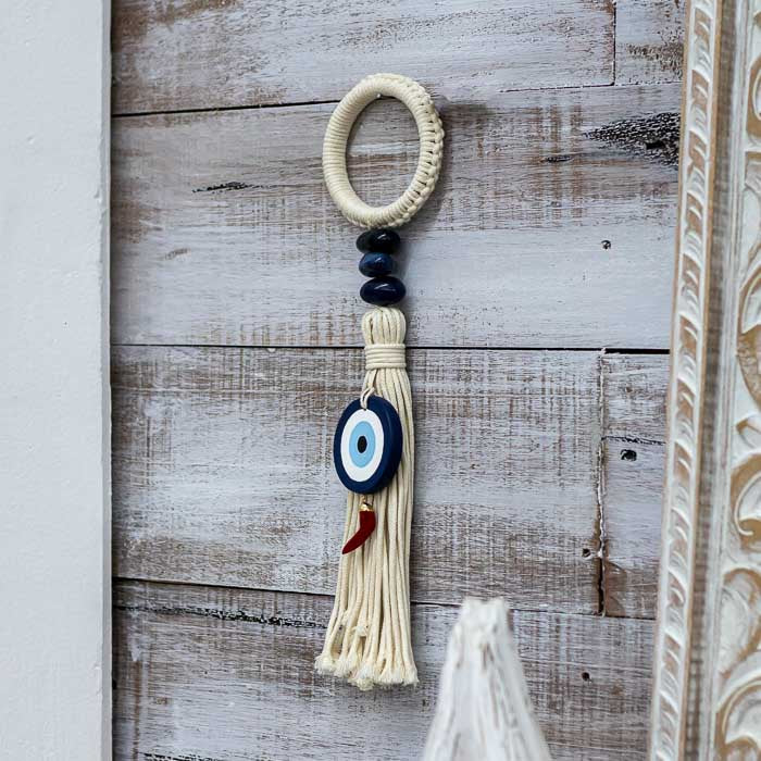 Peça decorativa espiritual com símbolo do Olho Grego e pendente de pimenta. 