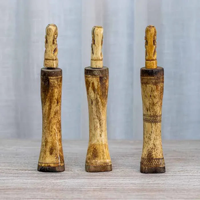 Detalhe de figura humana primitiva esculpida no topo da estrutura de osso.