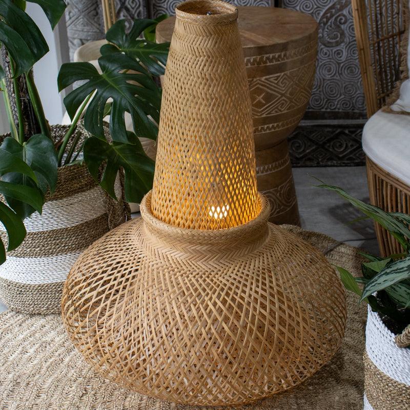Luminária de teto monumental indígena trançada em fibra de arumã com formato de tubo e base bojuda.