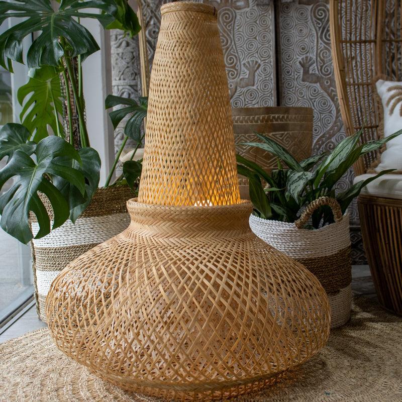 Luminária pendente de 80cm de altura instalada em ambiente de luxo rústico com plantas tropicais.
