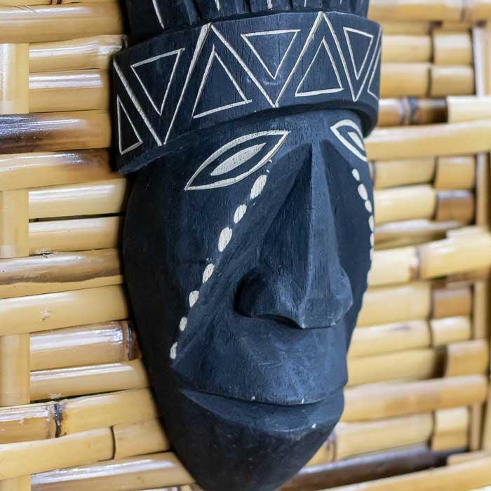 Arte brasileira em madeira com traços tribais e estilo decorativo ancestral.