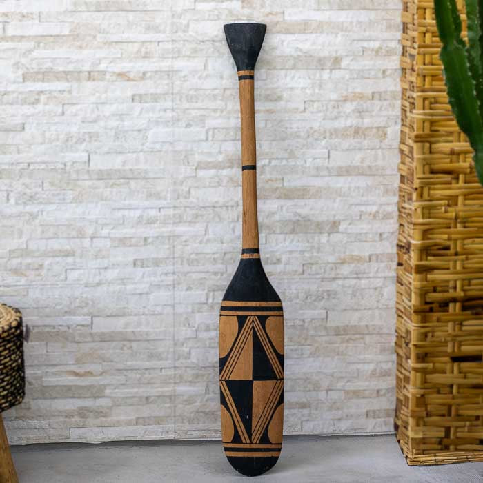 Remo decorativo feito à mão com traços inspirados na etnia indígena Waura, esculpido em madeira com acabamento natural 