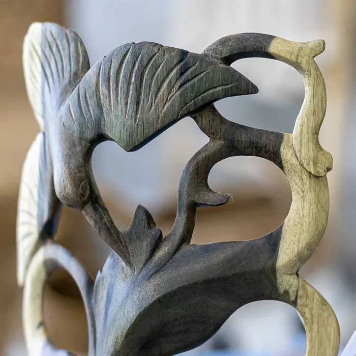 Escultura de parede com feição humana estilizada, esculpida em madeira hibiscus com design abstrato e acabamento natural 