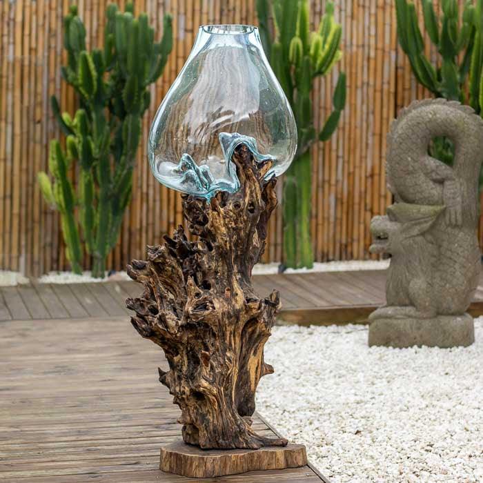Objeto decorativo com base rústica e cúpula em vidro moldado à mão. 