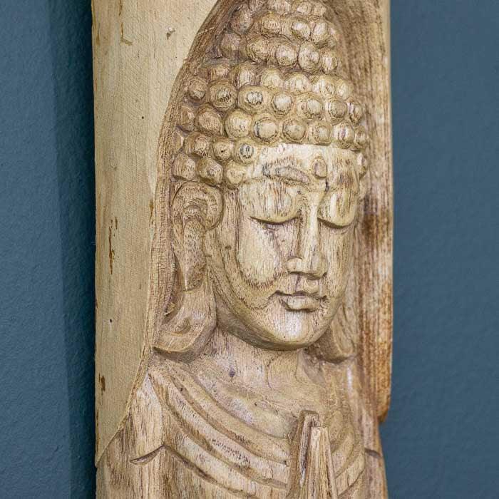 Arte espiritual entalhada em tronco com traços rústicos e serenos 