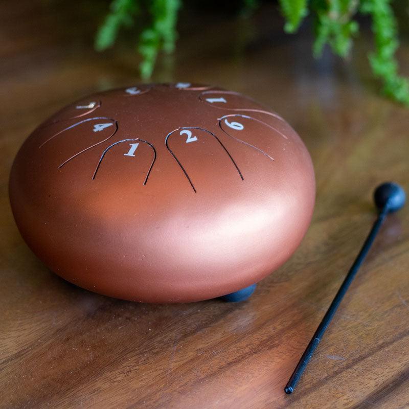 Percussão melódica portátil de 16cm de diâmetro, acompanhada de baqueta com ponta esférica para emissão de sons harmônicos. 