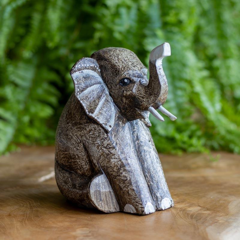 Escultura artesanal de Bali: elefante sentado em madeira entalhada.