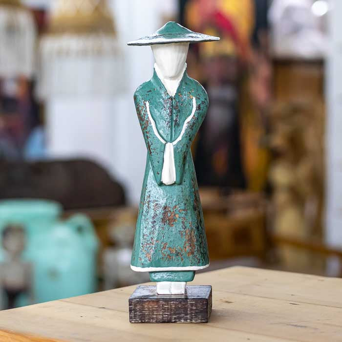 Escultura artesanal em madeira representando camponês balinês com detalhes entalhados que retratam o cotidiano rural