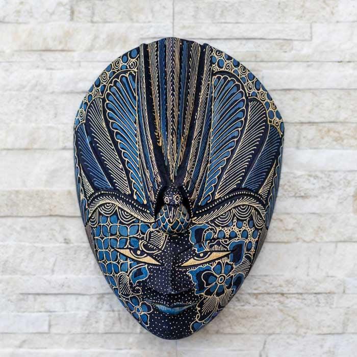 Máscara de madeira com estética tribal e pintura Batik detalhada, ideal para decoração étnica e autoral 