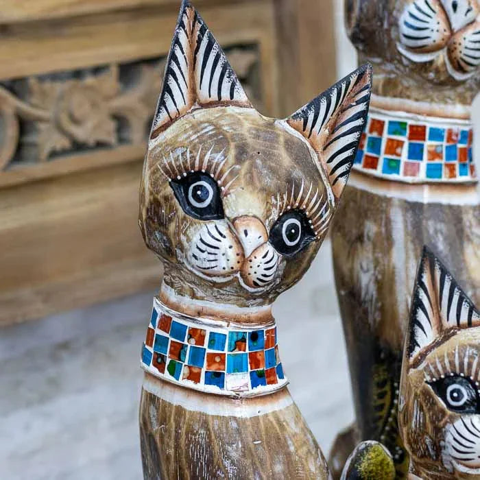 Esculturas de gatos artesanais em madeira natural com acabamento rústico.