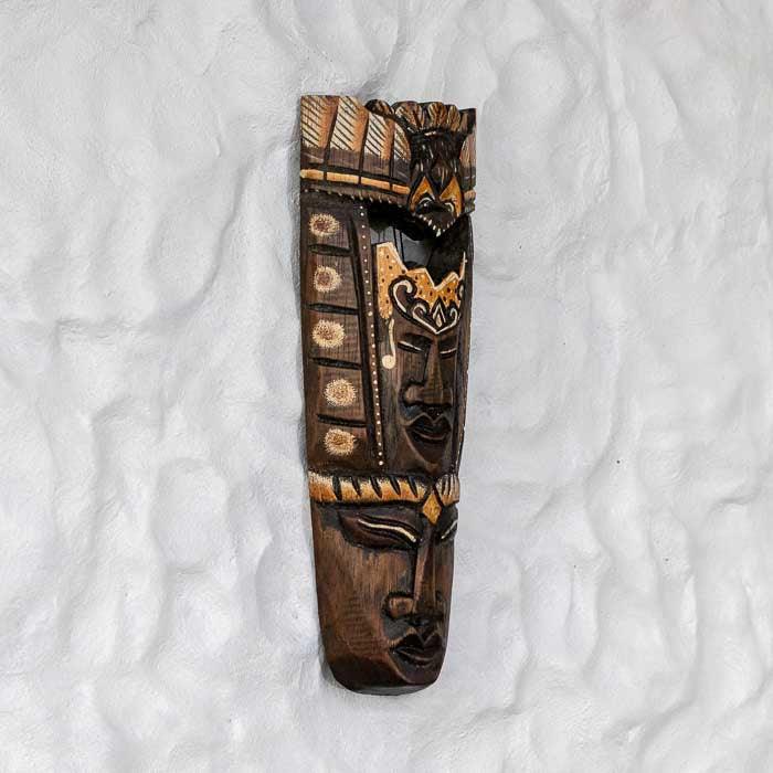 Escultura decorativa de Bali representando duas faces em harmonia.