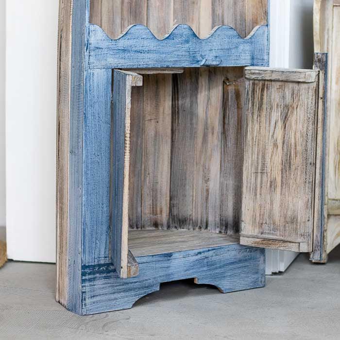 Móvel artesanal balinês com formato de barco, prateleiras internas e acabamento desgastado que realça o charme tropical. 