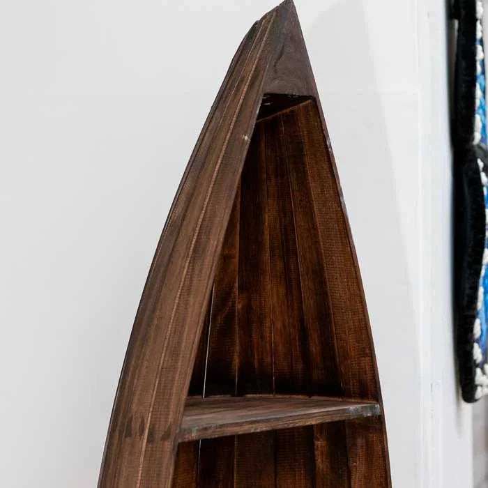 Móvel artesanal balinês em formato de barco, esculpido em madeira escura com prateleiras verticais ideais para livros e objetos decorativos.