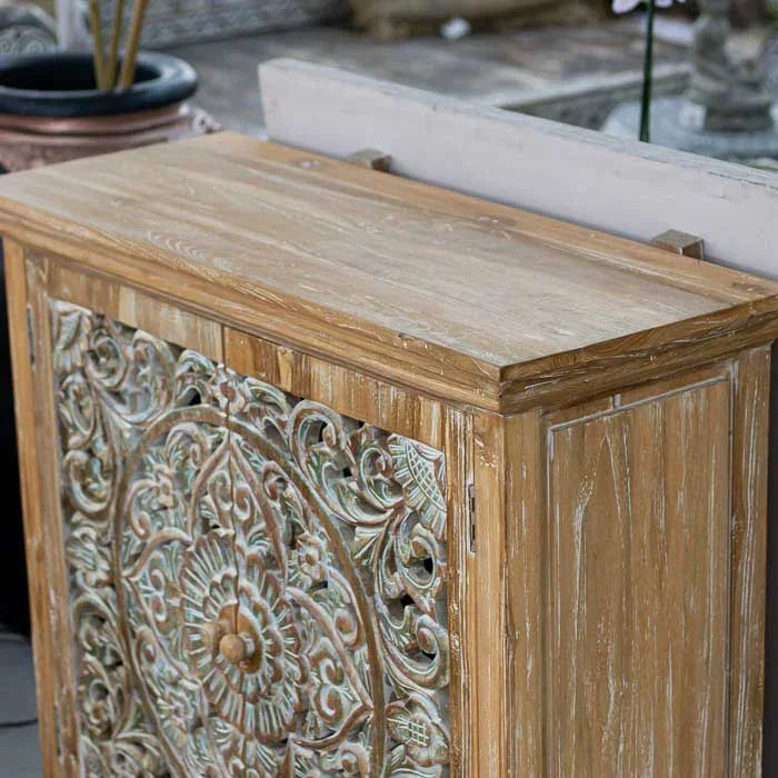 Estante de madeira com prateleira interna e entalhes de mandala floral, símbolo de harmonia e espiritualidade na arte artesanal de Bali.