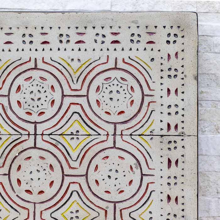 Objeto de arte tribal em fibrocimento destacando as texturas e cores terrosas do artesanato.