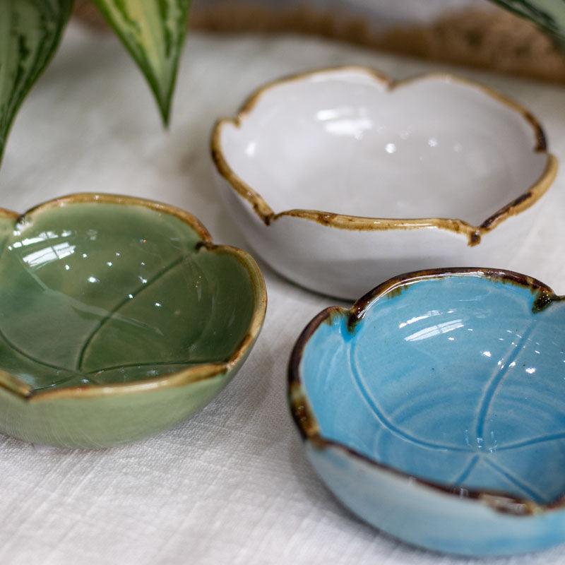 Bowls artesanais de Bali em formato de flor nas cores turquesa, branco e verde com detalhe de borda dourada.