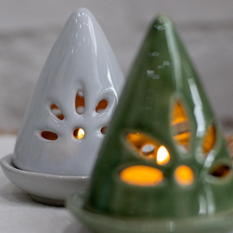 Porta-velas decorativo em formato de cone com recortes para passagem de luz.
