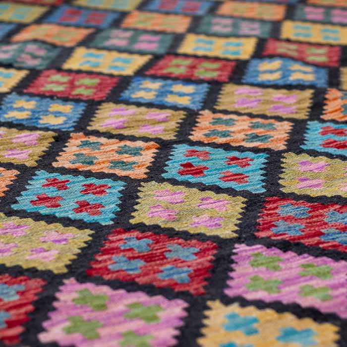 Tapete grande de 300x200cm em sala de estar decorada com poltronas de rattan, plantas e móveis de madeira de estilo rústico chic.