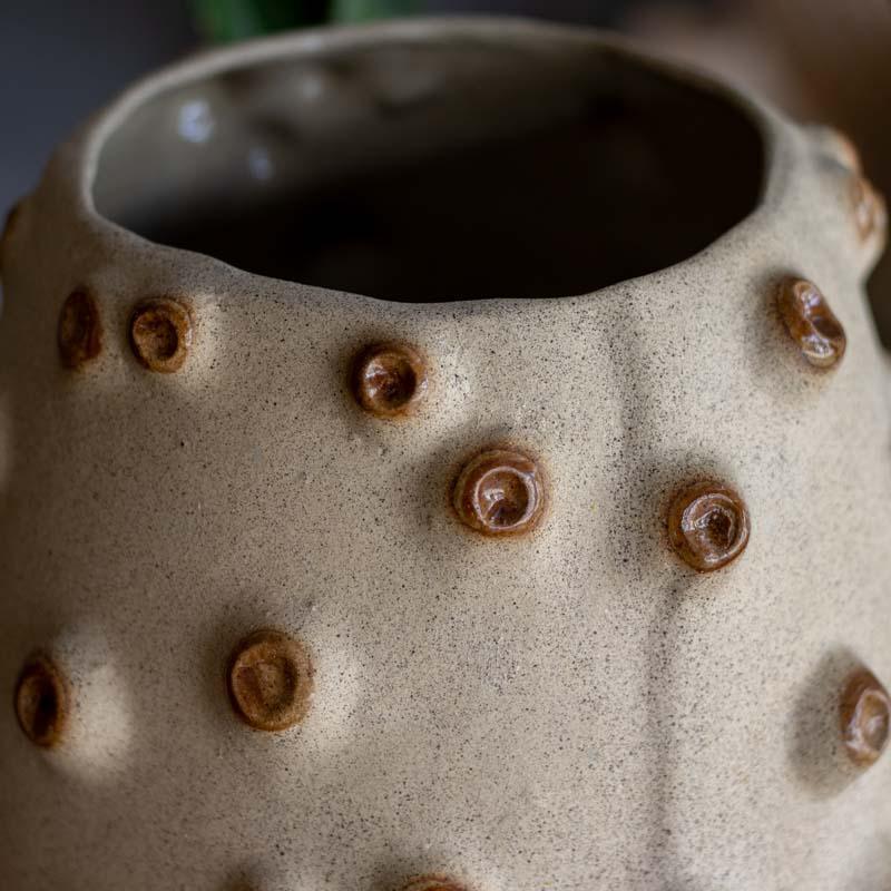 Vaso cachepot artesanal em cerâmica bege com relevos que imitam cracas do mar, assinado por Rosalva Siqueira.