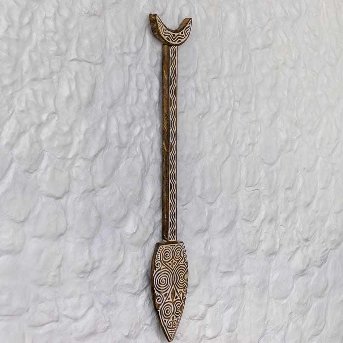 Obra cultural de Timor: remo de madeira com entalhes tribais decorativos.
