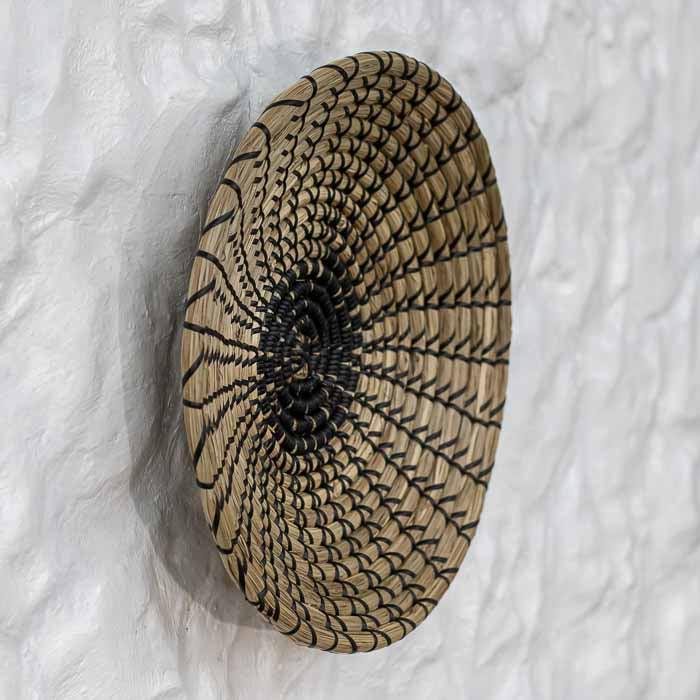 Cestaria Thao circular em fibras de rattan clara estilo boho tropical.