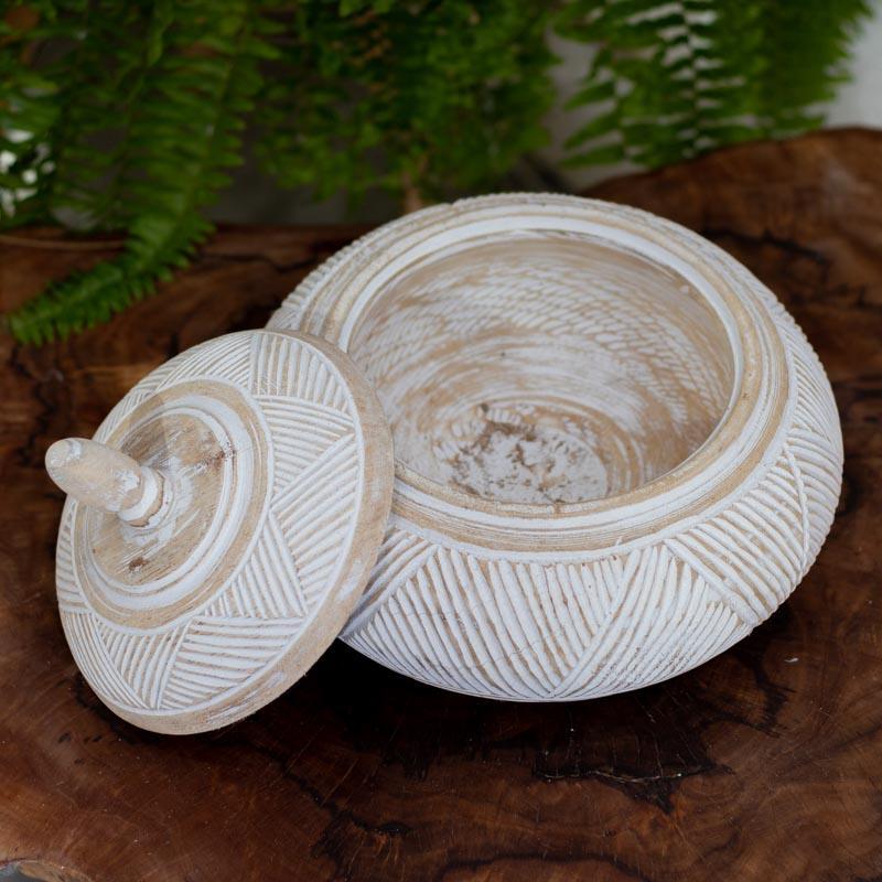 Pote feito à mão em madeira de Bali, com pátina clara e entalhes étnicos que combinam tradição artesanal, equilíbrio estético e elegância natural.