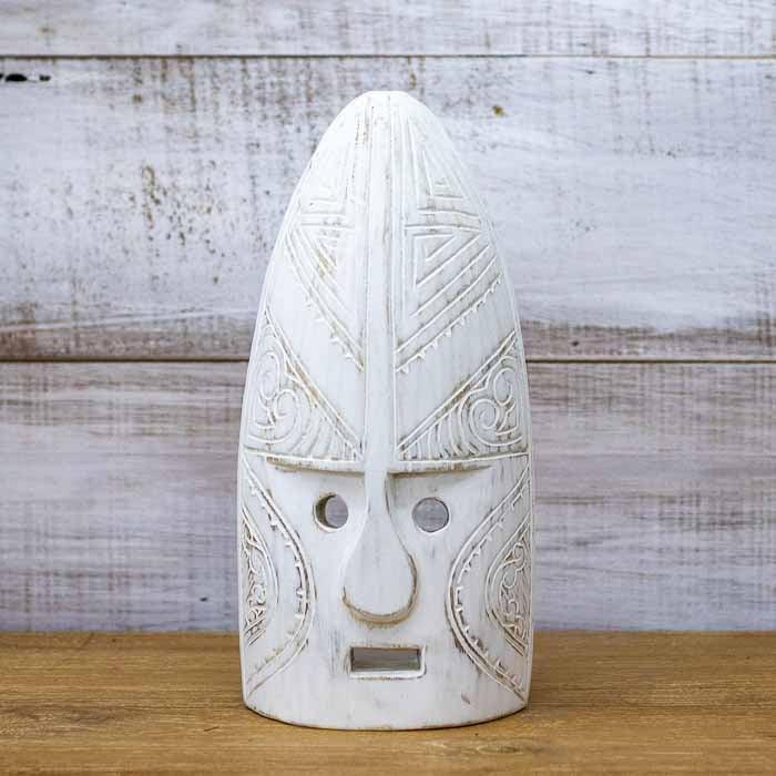 Máscara artesanal com orifícios circulares nos olhos e boca retangular, característica do artesanato autêntico de Timor.