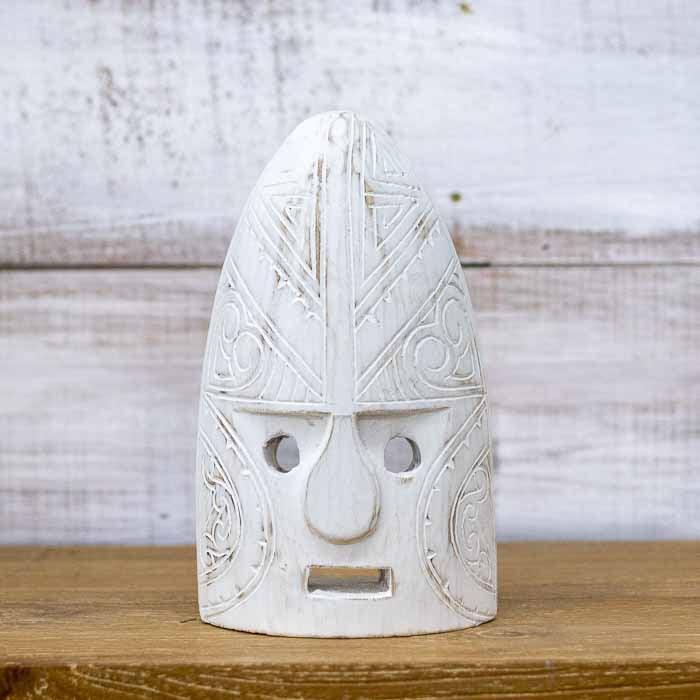 Máscara étnica artesanal de Timor esculpida em madeira com acabamento pátina branca e detalhes entalhados.