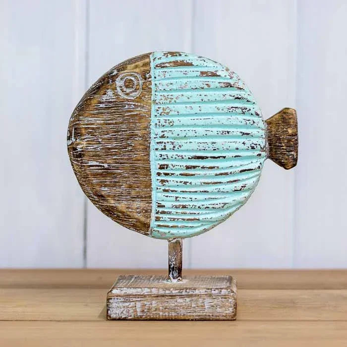 Peixes-balão decorativos em tons naturais posicionados sobre uma mesa de centro em ambiente com decoração temática litorânea. 