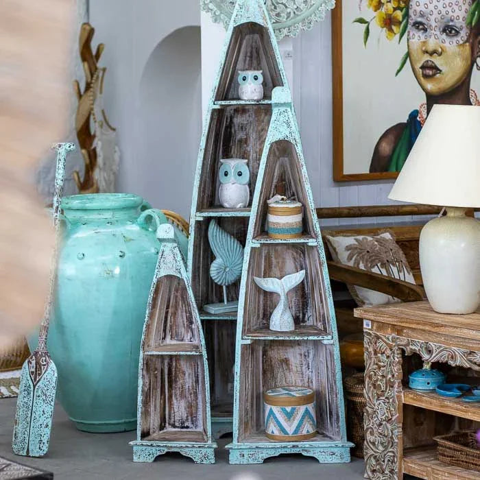 Arte balinesa em formato de barco, estante artesanal de madeira com pátina azulada e estilo tropical, perfeita para ambientes costeiros e boêmios. 
