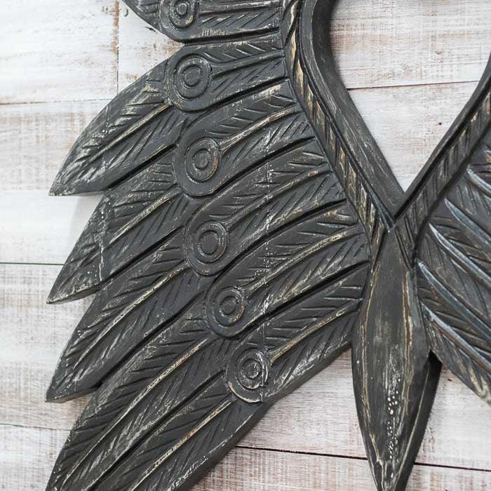Escultura de parede em madeira artesanal da Indonésia, com entalhes detalhados e design inspirado nas asas simbólicas das tribos de Bornéu. 