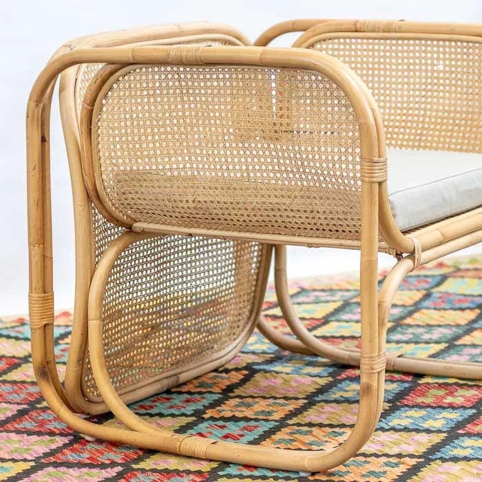 Poltrona de rattan para decoração boho, feita à mão, em ambiente com tapete orgânico.
