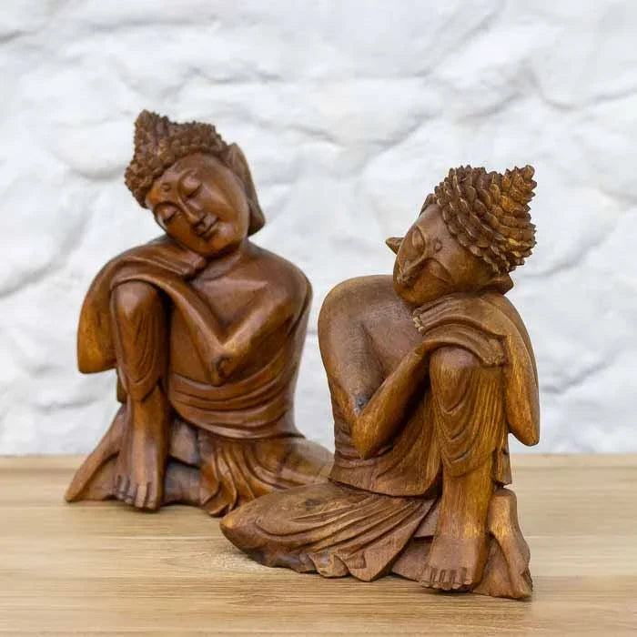 Escultura feita à mão de Buddha relaxando sobre a perna produzido em madeira suar para compor ambientes zen e de presença espiritual.