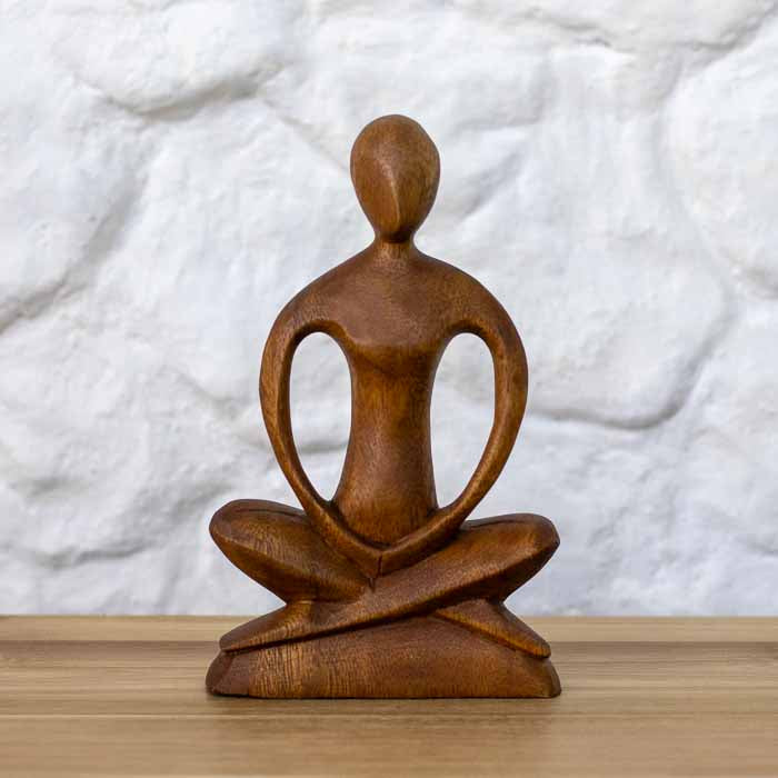 Escultura feita à mão em bali de homem praticante de yoga em posição de Lótus para meditação.