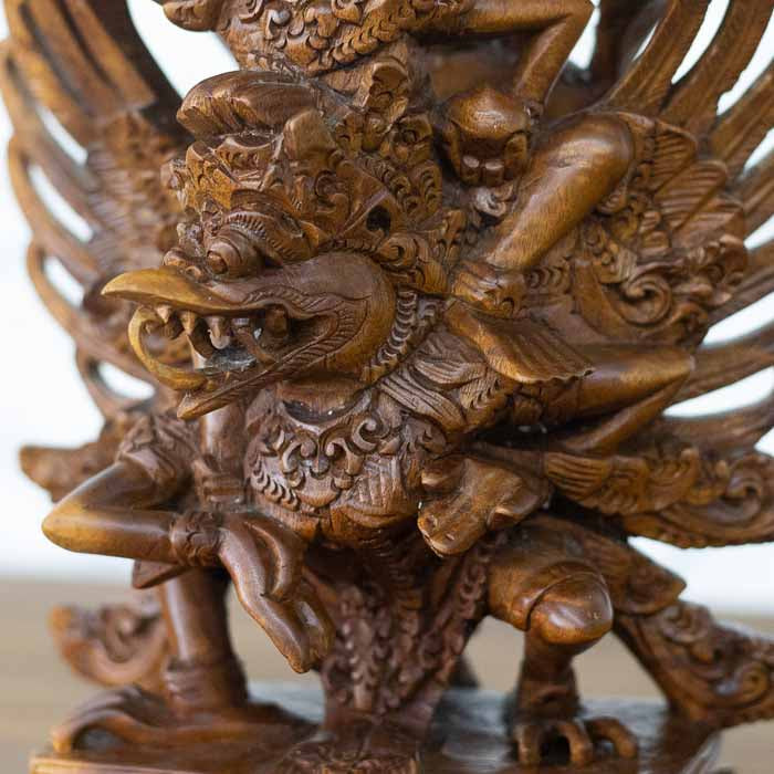 Obra de arte sacra hindu esculpida em um único bloco de madeira com as asas de Garuda e a coroa de Vishnu. 