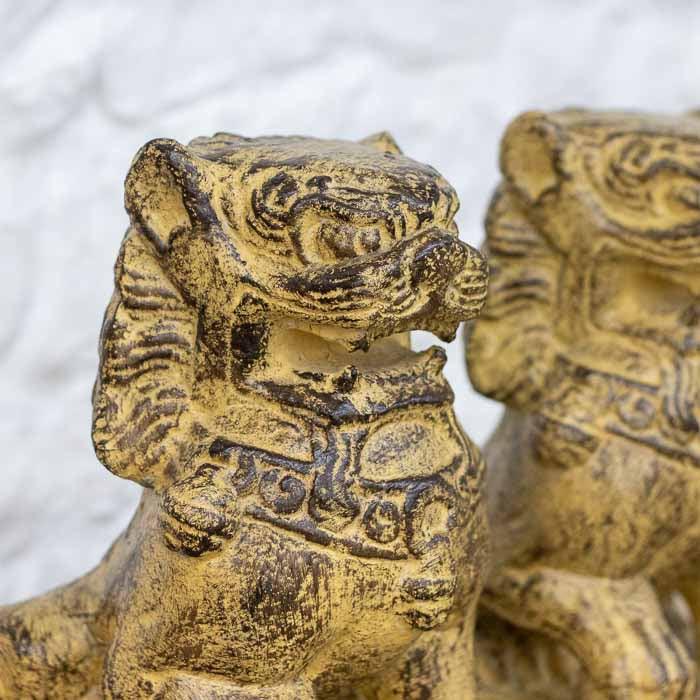 Leões guardiões orientais sobre mesa de madeira em Bali.